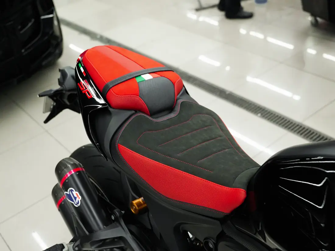 The same Ducati seat rebuilt by DEIZ with suede-finish panels, red perforated leather and contrast stitching
